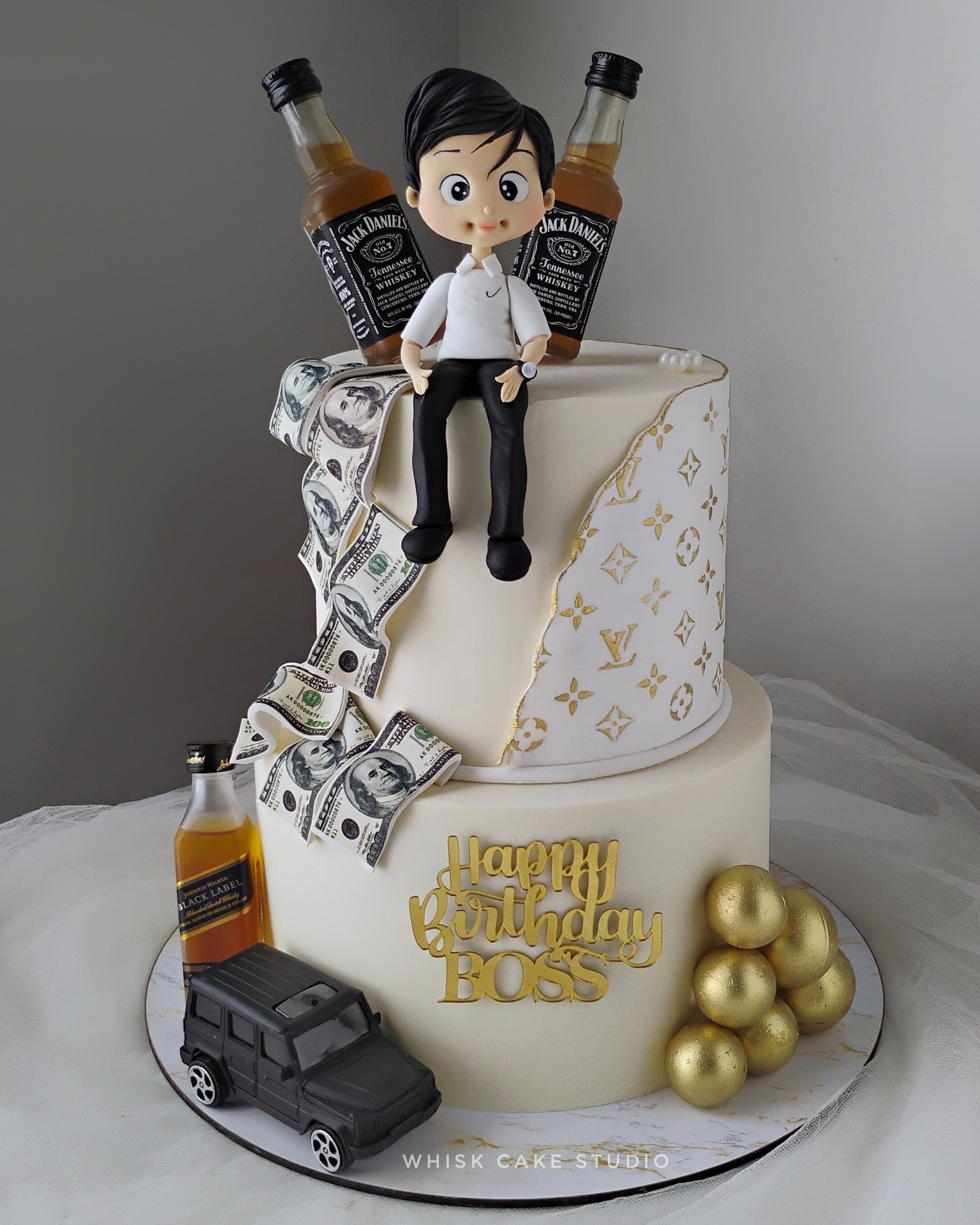 Two-tier birthday cake for men with his favorite things around, Jack Daniel's bottles, money, car and golden balls.